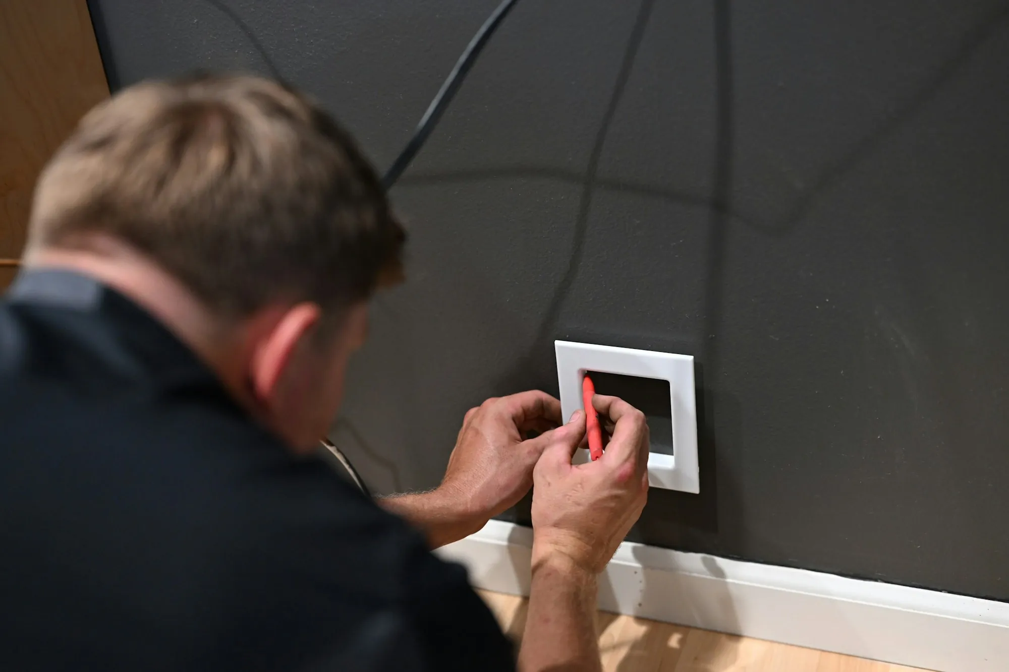 Electrician fitting a new wall switch plate