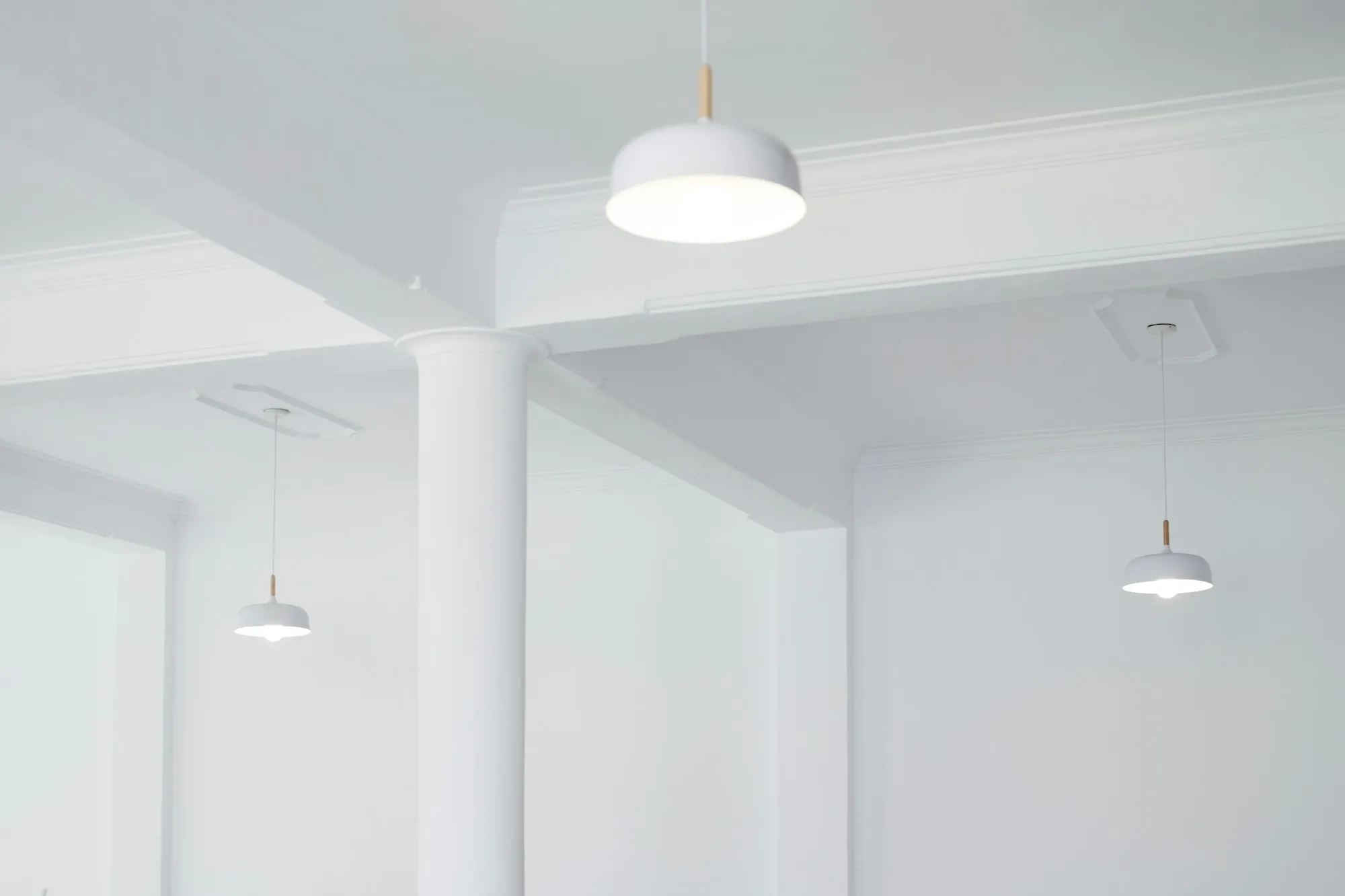 Pendant lights glowing in a bright white room